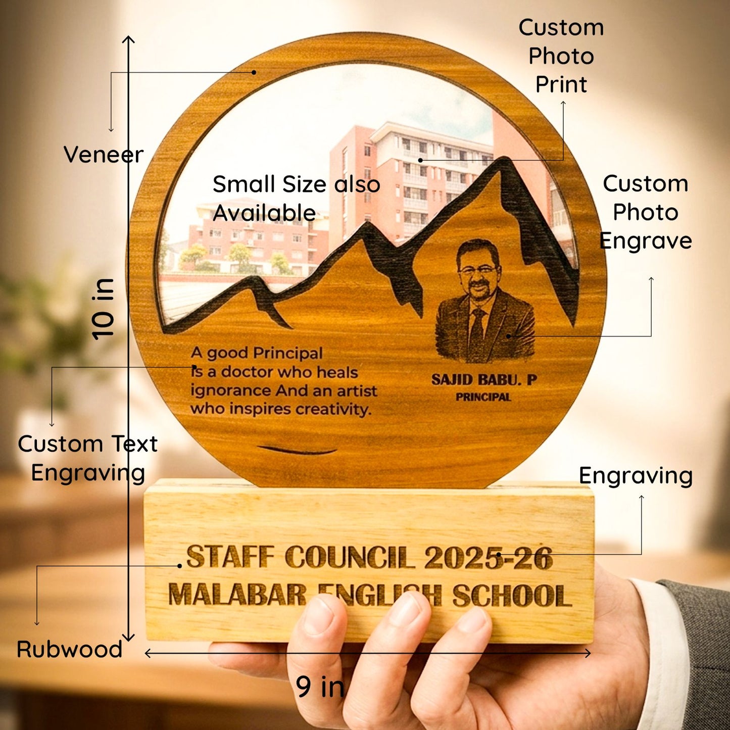 A hand holds a custom engraved wooden school staff council plaque and base. The round top features a veneer finish with an engraved mountain graphic, a portrait, and text, with callouts indicating 10 in height and 9 in width.